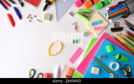 Assortment of colorful school supplies on white desk. Top view. Horizontal composition. Stock Photo