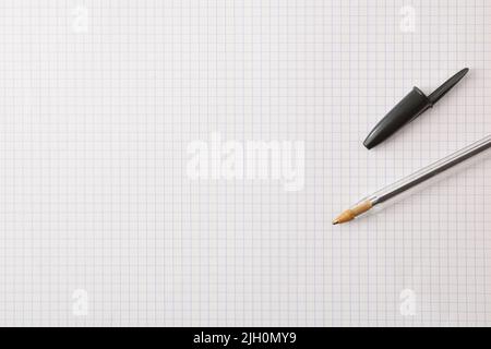 Teaching and education background with pen on checkered paper. Top view. Stock Photo