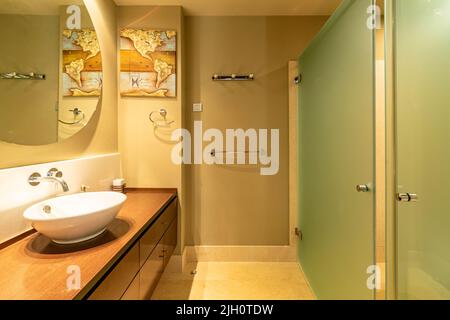 a view from inside a bathroom in front of a large circular mirror in an apartment along the Costa Del Sol Stock Photo