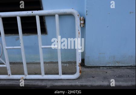 Part of damaged fence door, broken hinge, The door is rusty Stock Photo