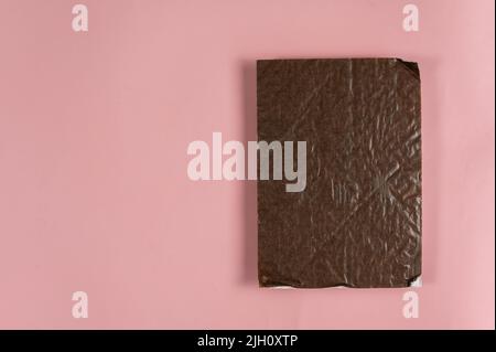 Rectangular piece of brown cardboard against the pink background. Copy space for text and design elements. Top view. Stock Photo