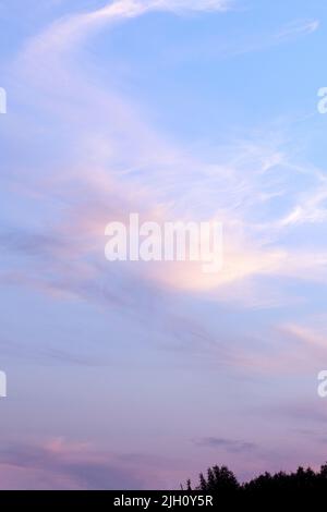 Romantic sunset sky background with soft clouds. Sunset light colors clouds in red, blue, pink and purple. Stock Photo