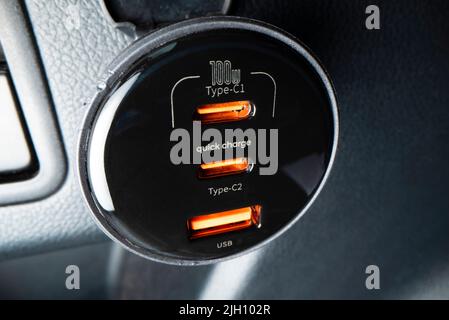 Close-up view of powerful car charger with USB type C and type A ports, shot with macro probe lens Stock Photo