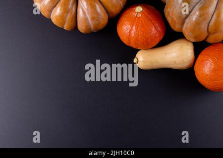Composition of multiple orange pumpkins lying on black background Stock Photo
