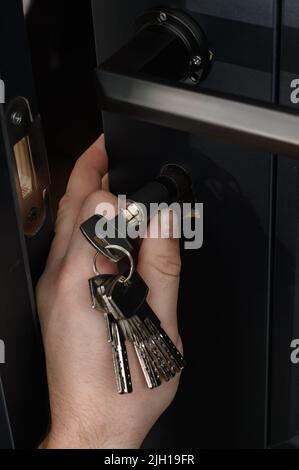 The master installs the core for the door lock, installation work with the door. Stock Photo