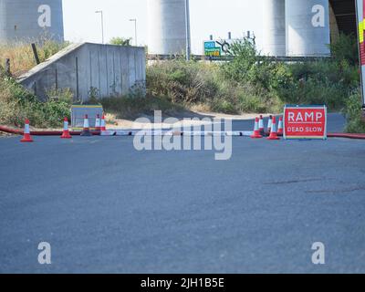 Iwade, Kent, UK. 14th July, 2022. Problems remain with Isle of Sheppey's water supply. Some residents are still without water nearly 3 days after the main water pipe supplying the island burst - although many in Sheerness & Minster were reconnected late last night. A long (reported to be 5km) fire hose is being used to pump water near the Sheppey Crossing to help resolve the problem (according to Kent Online) - but even this sprung a leak with water seen shooting high into the air (repaired by the time of these pics). Credit: James Bell/Alamy Live News Stock Photo