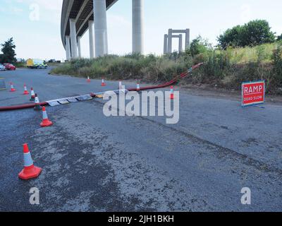 Iwade, Kent, UK. 14th July, 2022. Problems remain with Isle of Sheppey's water supply. Some residents are still without water nearly 3 days after the main water pipe supplying the island burst - although many in Sheerness & Minster were reconnected late last night. A long (reported to be 5km) fire hose is being used to pump water near the Sheppey Crossing to help resolve the problem (according to Kent Online) - but even this sprung a leak with water seen shooting high into the air (repaired by the time of these pics). Credit: James Bell/Alamy Live News Stock Photo