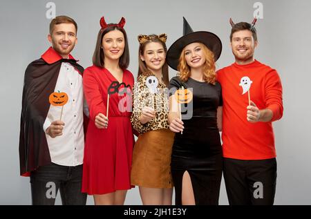 friends in halloween costumes with party props Stock Photo