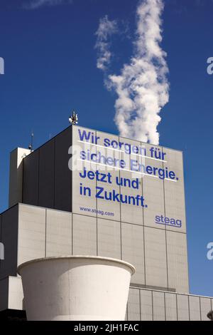 Herten Germany, July 14, 2022: Inscription *'We ensure safe energy. Now and in the future'* on a block of the STEAG cogeneration plant in Herten promises safe energy for the future through hard coal. The Herne combined heat and power plant only has one block in which not only electricity but also district heating for the Ruhr district heating network is generated from hard coal. Stock Photo