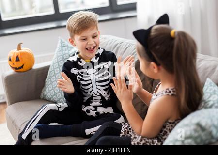 kids in halloween costumes playing game at home Stock Photo