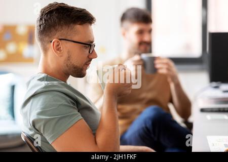 men or startuppers drinking coffee at office Stock Photo