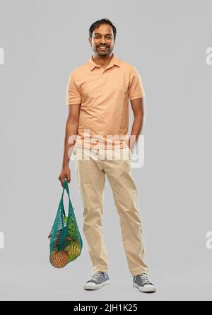 happy indian man with food in reusable net tote Stock Photo