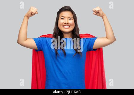 happy asian woman in red superhero cape Stock Photo