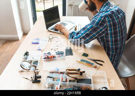 Busy programmer drinking coffee at workplace Stock Photo