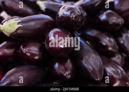 Fresh eggplant on market counter Stock Photo