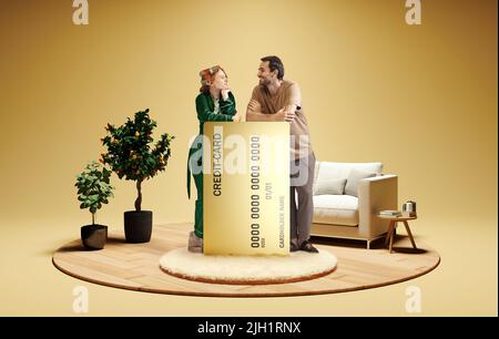 Happy family couple standing near to huge 3d model of credit card at home interior isolated on golden color background. New app, mortgage, lending, ad Stock Photo