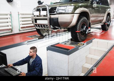 SUV undergoing auto wheel alignment in garage Stock Photo