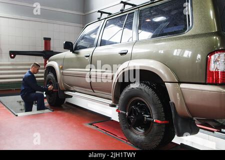 Wheel alignment for SUV in professional workshop Stock Photo