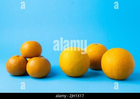 Natural tangerines and oranges on blue background Stock Photo