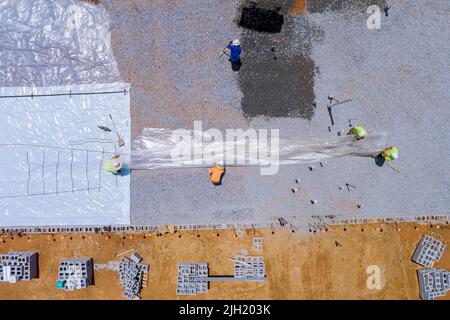Preparation for pouring concrete with excavator bucket working in leveling gravel the building foundation Stock Photo