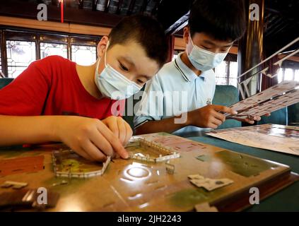 Suzhou, China's Jiangsu Province. 14th July, 2022. Children make paper model of classical gardens at an archives center in Suzhou, east China's Jiangsu Province, July 14, 2022. Credit: Hang Xingwei/Xinhua/Alamy Live News Stock Photo