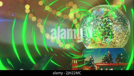 Image of light spots over snow globe with christmas tree Stock Photo