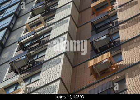 Facade of apartment building with decorative air conditioner covers. Stock Photo