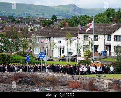 The coffin of John Steele is carried by mourners up Churchill Road, past the remnants of the bonfire from which he fell, following his funeral service at his house in Larne, County Antrim. Mr. Steele fell to his death on Saturday while helping to build a bonfire. Picture date: Thursday July 14, 2022. Stock Photo