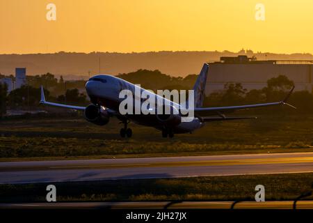 Malta Air Boeing 737-8 MAX 200 (REG: 9H-VUA) taking off from runway 13 with the sun setting down behind. Stock Photo