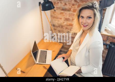 blond Caucasian pregnant woman working at home, medium shot working in pregnancy. High quality photo Stock Photo