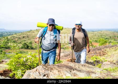 Middle aged hiker with backpack climbing mountian - concept of freedom, active leisure lifestyle and holidays Stock Photo