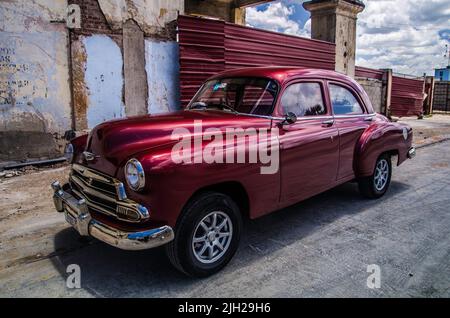 Antique restored red car in the old streets of Havana Stock Photo