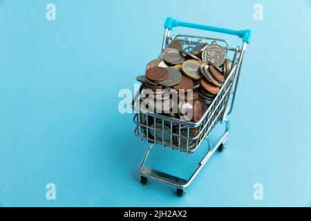 Shopping cart full of UK sterling coins. Cost of shopping concept Stock Photo