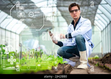 Portrait of handsome agricultural researcher holding tablet while working on research at plantation in industrial greenhouse Stock Photo