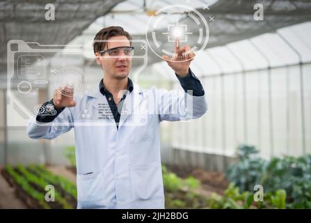 Portrait of handsome agricultural researcher working on research at plantation in industrial greenhouse Stock Photo