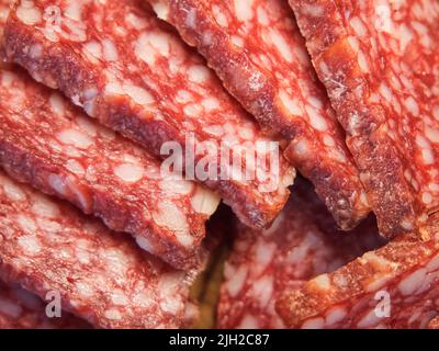 Smoked sausage, full frame. Pieces of appetizing meat snack close-up. Sliced sausage as background, meat delicatessen Stock Photo