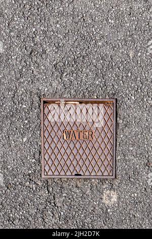 An outside stopcock with metal cover to access mains water supply. UK water security. Space for text. Magazine, Poster. Stock Photo