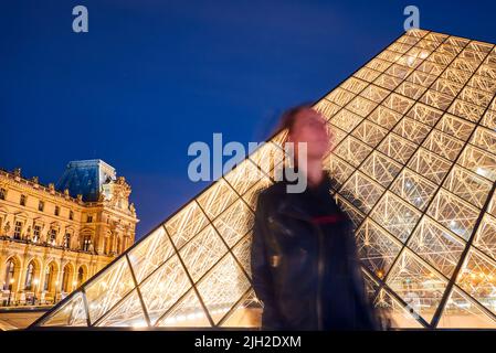 silhouette of a girl on a Louvre museum background in Paris at night Stock Photo