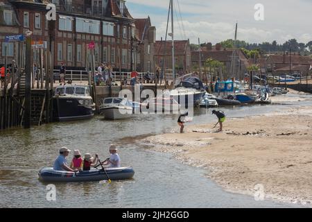 Family summer UK, view in summer of children enjoying a summer afternoon in Blakeney harbour, a traditional holiday town on the north Norfolk coast UK Stock Photo