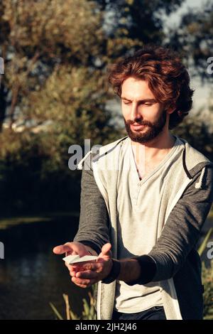 Attractive bearded man holding paper airplane Stock Photo