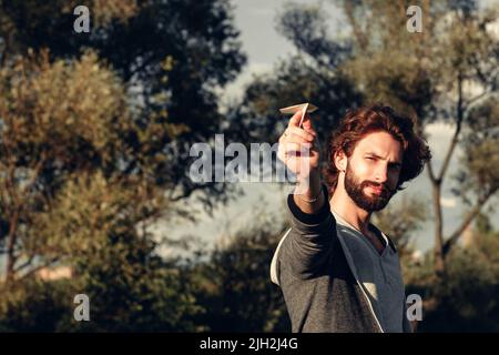 Man aiming paper airplane to camera free space Stock Photo