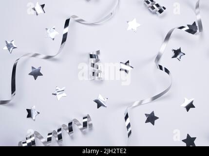White background with a silver serpentine and stars. concept of celebrating a birthday,newborn , party or anniversary in silver tones. High quality photo Stock Photo