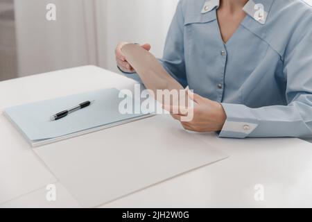 Doctor holding an insole while sitting at a table. Orthopedist tests the medical device. Orthopedic insoles. Foot care. Flat Feet Correction Stock Photo