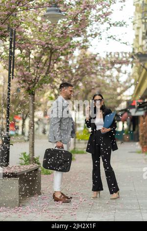 Two business people are laughing under the falling flower leafs Stock Photo