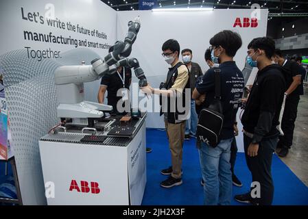 Bangkok, Thailand. 14th July, 2022. People interact with a robot at the RoboCup in BITEC Bangna. RoboCup 2022 in Thailand is the world's largest robotic and AI event during which 3,000 participants from 45 countries are expected to attend. The event will be held from 13 to 17 July 2022. (Photo by Peerapon Boonyakiat/SOPA Images/Sipa USA) Credit: Sipa USA/Alamy Live News Stock Photo