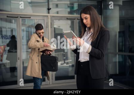 Assistent is taking notes from his phone call while his boss is looking at the plans Stock Photo