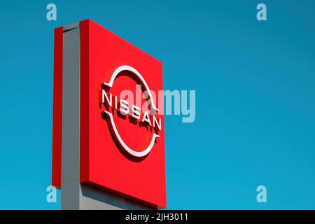 Minsk, BELARUS - May 10, 2022: Red Nissan logo on a billboard near a car dealership Stock Photo