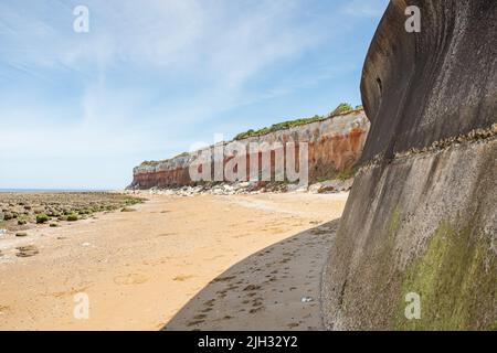 The curving seawall and promenade at Hunstanton meets the red and white coloured cliffs on the West Norfolk coast seen in July 2022. Stock Photo