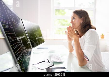 Programmer Woman Coding On Multiple Computer Screens Stock Photo