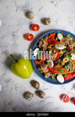 Healthy hearty salad of tuna, tomatoes, eggs, tuna, olives close-up in a bowl on the table. Salad Nicoise. French cuisine. View from above Stock Photo